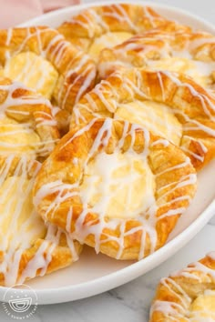 a white plate topped with pastries covered in icing