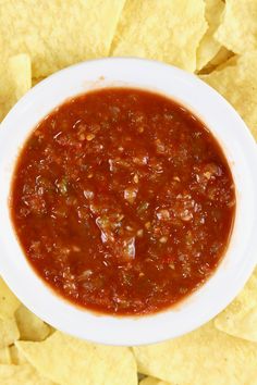 a white bowl filled with chili and tortilla chips on top of a table