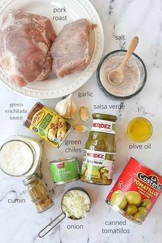 ingredients to make stuffed chicken are shown on a marble counter top, including olives, garlic and seasonings