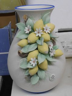 Oggettistica e complementi in ceramica decorati con limoni, foglie e fiori in rilievo, realizzati e dipinti a mano. Capodimonte Porcelain Flowers, Embroidery Neck Designs, Neck Designs, Flower Pots, Vase, Design