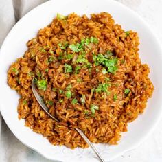 a white plate topped with rice and garnished with cilantro