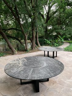 two circular tables sitting on top of a stone patio