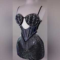 a black and white dress with silver sequins on it's bust, made to look like a corset