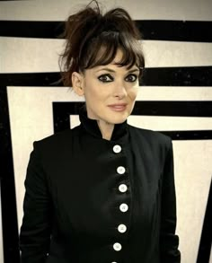 a woman with dark hair wearing a black jacket