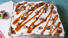 a cake with white frosting and caramel drizzle on top