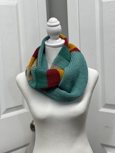 a white mannequin wearing a multicolored scarf on top of a head