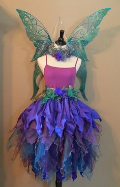 a purple and green dress on a mannequin headdress with butterfly wings