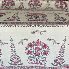 an embroidered table cloth with birds and flowers on it