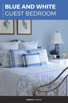 a blue bedroom with white and blue bedding, pictures on the wall and lamp