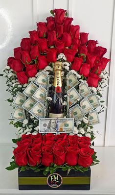 a bouquet of red roses and money is arranged in the shape of a wine bottle