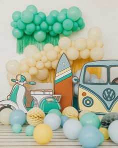 a table topped with balloons and decorations next to a scooter on the wall