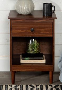 a nightstand with a plant and books on it