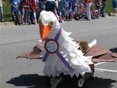 a parade float in the shape of a bird with a ribbon on it's head