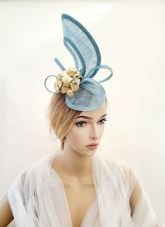 "Presenting a beautiful baby blue sinamay straw percher hat fascinator with gold leather leaf detail.  Attached by your choice of colour satin ribbon wrapped headband or millinery elastic. If you would like the design customising at all, or an alternate colourway please get in touch with me and I will be delighted to help.  All our hats are handmade in the UK using traditional millinery techniques. These items are made to order (unless otherwise specified) and take hours of work, please refrain Handmade Gold Hat For Kentucky Derby, Adjustable Light Blue Fascinator For Royal Ascot, Adjustable Gold Mini Hats For Spring, Gold Hair Accessories For Spring Wedding, Adjustable Gold Top Hat For Royal Ascot, Gold Costume Hats And Headpieces For Races In Spring, Gold Costume Hats And Headpieces For Spring Races, Gold Headpiece For Summer Church Events, Handmade Gold Hats For Party