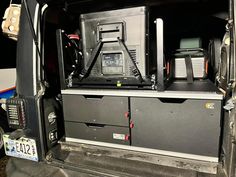 the back end of a van with its doors open and electronic equipment in it's compartment