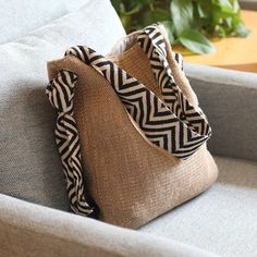 a bag sitting on top of a couch next to a plant