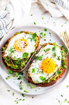 two eggs on toast with avocado sprouts and parsley in the middle