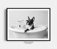 a black and white photo of a dog sitting in a bathtub reading a newspaper