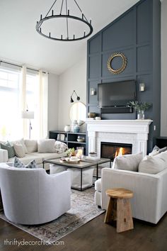 a living room filled with furniture and a fire place in front of a tv mounted on the wall