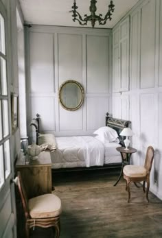 a bedroom with white walls and wood floors, an antique bed is in the corner