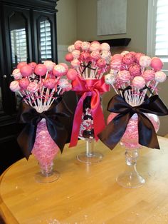 two vases filled with pink and white flowers on top of a dining room table