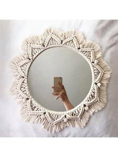 a person taking a selfie in front of a round mirror with fringes on it