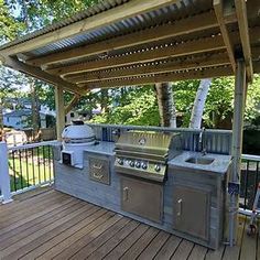 an outdoor kitchen with grill and sink on the deck