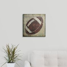 a living room with a white couch and a painting on the wall that has a football on it