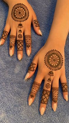 two hands with henna tattoos on them