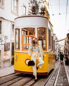 a woman taking a photo in front of a trolly car