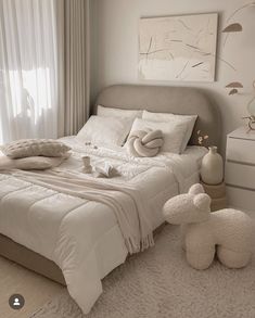 a bed with white sheets and pillows on top of it next to a teddy bear