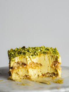 a piece of cake sitting on top of a white plate covered in green toppings