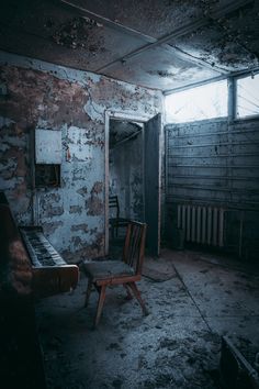 an abandoned room with a chair and piano