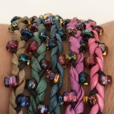 "This is the adult version of the summer friendship bracelet that you made in your youth. You will love the luxury of the silk on your skin, and the shimmer of the glass beads when you wear them. This is my Marsha Neal Studio Muted Garden silk color palette. And I have made a custom bead mix of Miyuki size 5 triangle beads to coordinate. I have picked out 1mm cotton cords and my ceramic disc beads glazed in various colors to give you a palette that works together. I also offer these without my c Adult Friendship Bracelets, Fabric Necklaces, Silk Wrap Bracelets, Diy Summer Crafts, Cloth Jewelry, Silk Bracelet, Bracelet Kit, Summer Craft, Fabric Bracelets