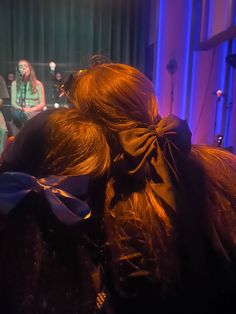 the back of a woman's head as she sits in front of an audience