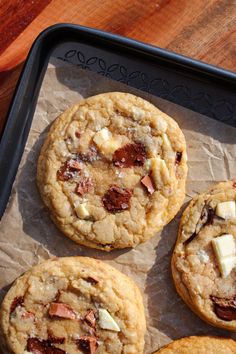 four cookies are sitting on a tray with some butter and other toppings around them