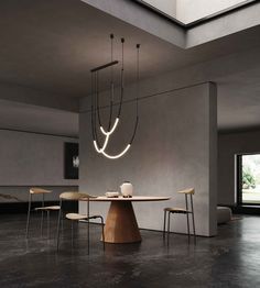 a dining room with a table, chairs and lights hanging from it's ceiling