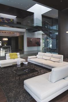 a living room filled with white furniture and lots of windows