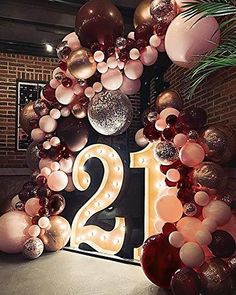 the number twenty is surrounded by balloons and streamers in pink, gold and silver