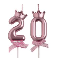 the number 20 is made out of pink foil and sits on top of a stick