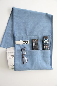 there is a remote control and some other items in the pocket on top of a blue cloth