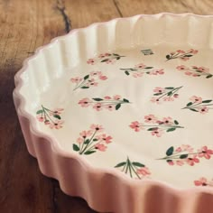 a pink flowered dish sitting on top of a wooden table