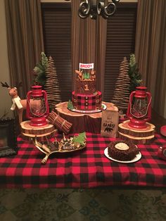 a table topped with red and black plaid cloth covered tables next to a christmas tree