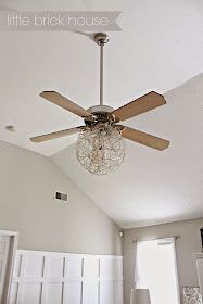 a living room with a ceiling fan and chandelier