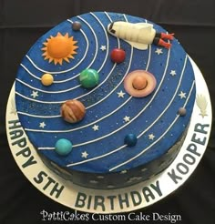 a birthday cake with an image of the solar system on it's side and stars