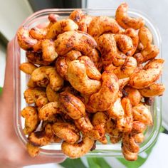 a person holding up a plastic container filled with fried food