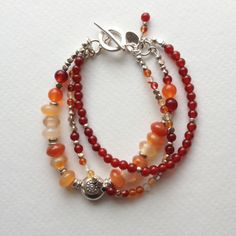 Carnelian and Hill Tribe Sterling Silver Triple Strand Bracelet. $75.00, via Etsy. Silver Carnelian Jewelry With Gemstone Beads, Bohemian Silver Beaded Necklaces With Carnelian, Multicolor Beaded Carnelian Jewelry, Red Multi-strand Beaded Bracelets, Amber Multi-strand Jewelry With Gemstone Beads, Multi Strand Bracelet, Ginger Snaps, Flower Beads, Strand Bracelet