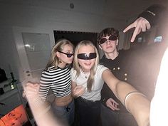 three people wearing blindfolds pose for the camera