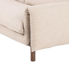 a close up view of the back end of a beige couch with wood legs and arms