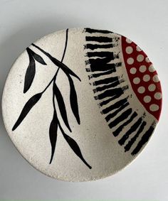 a ceramic plate with black and red designs on it